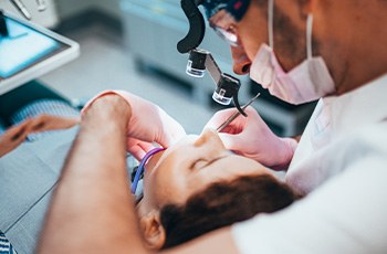 A dentist performing a root canal on a patient