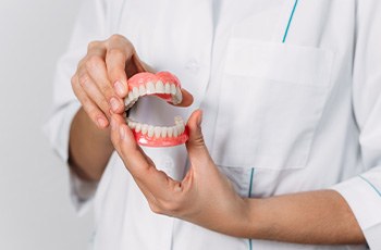 Close up of dentist holding two dentures